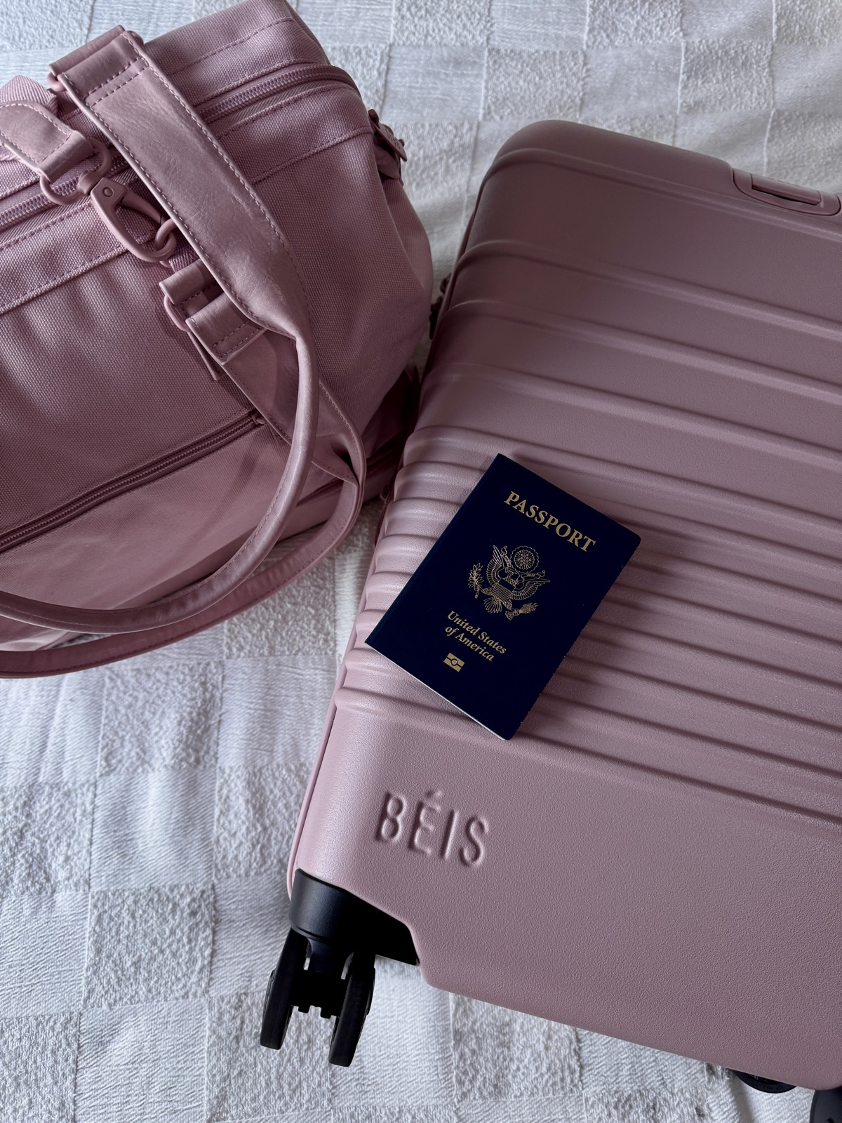A pink BÉIS suitcase and passport laid out