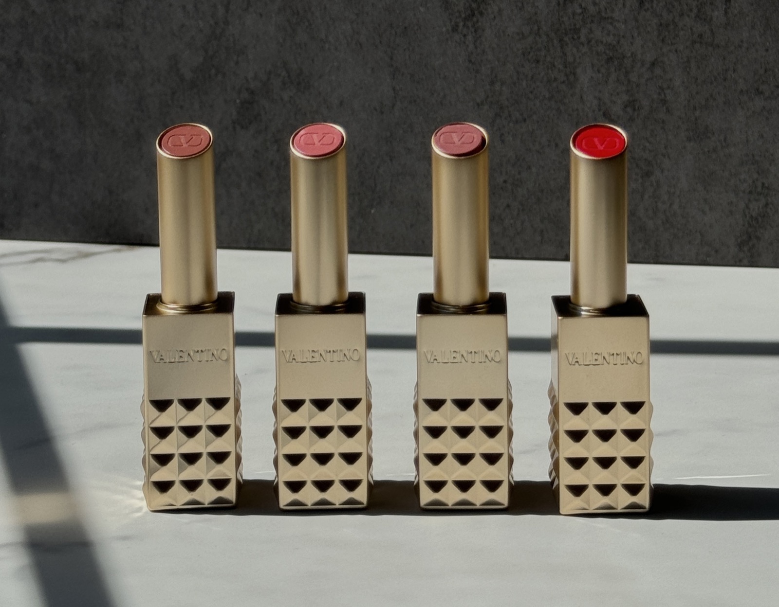 Four Valentino Beauty lipsticks lined up in a row