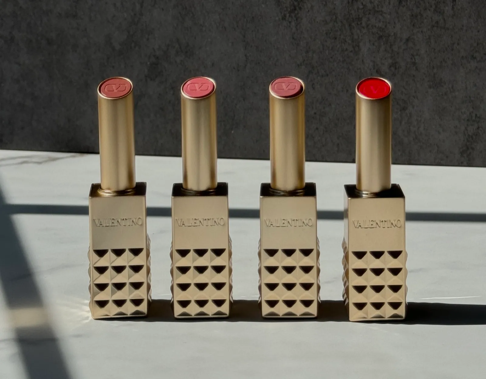 Four Valentino Beauty lipsticks lined up in a row